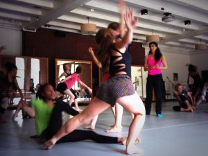 Nejla looks on as dancers improvise partner work in her Modern Repertory class. Students will perform an excerpt of the work during their final performance.